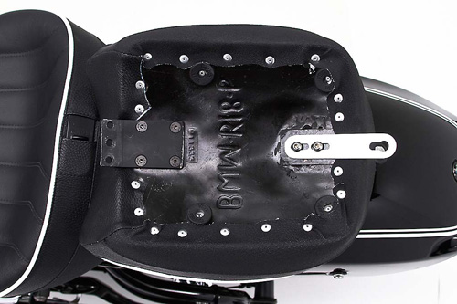 a person holding Classic Solo seat showing the back side heater wiring, MPN printed and mounting brackets pre-installed