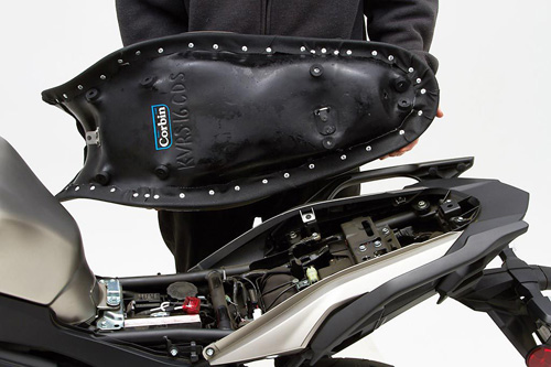 a person holding Canyon Dual Sport seat showing the back side, MPN printed and mounting brackets pre-installed