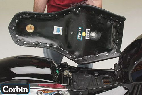 a person holding Young Guns seat showing the back side and mounting brackets pre-installed