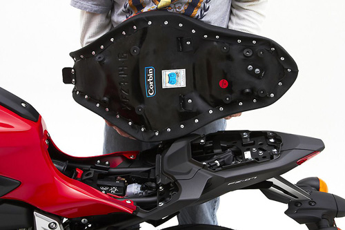 a person holding Gunfighter & Lady seat showing the rear side, MPN printed and mounting brackets pre-installed