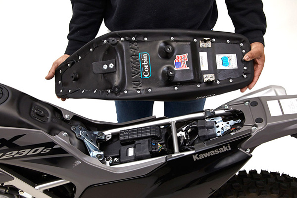 a person holding Dual Sport seat showing the rear side with MPN printed and mounting brackets pre-installed