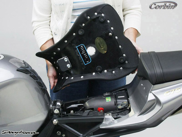 a person holding Front seat showing the rear side, mounting brackets pre-installed and Stainless steel locking pin