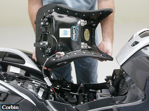 a person is hodling front seat showing rear side mounting brackets and wiring harness