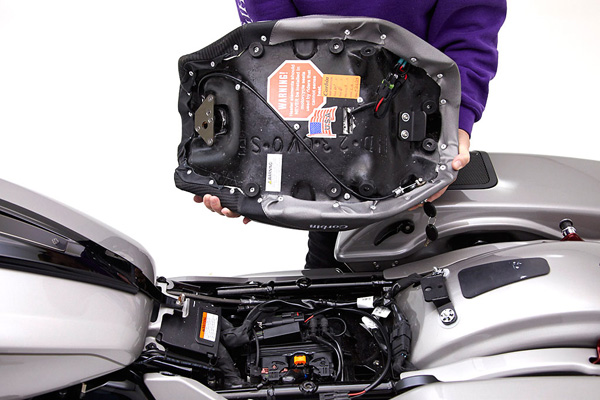 a person is holding solo seat showing rear side of seat with MPN printed and mounting brackets preinstalled