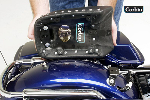 a person is holding pillion seat showing rear side mounting brackets pre-installed