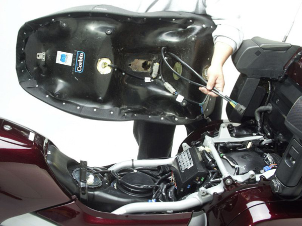 a person is holding seat , showing rear side heater wiring jack