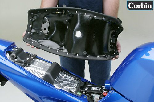 a person is holding gunfighter seat showing rear side, with mounting brackets pre installed