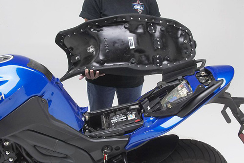 a person is hodling Canyon Dual sport seat showing rear side MPN printed and mounting brackets preinstalled