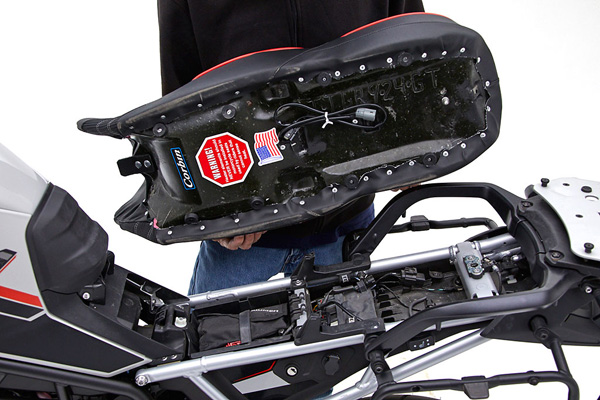 a person is holding Seat showing basepan with heater wiring and mounting brackets pre-installed