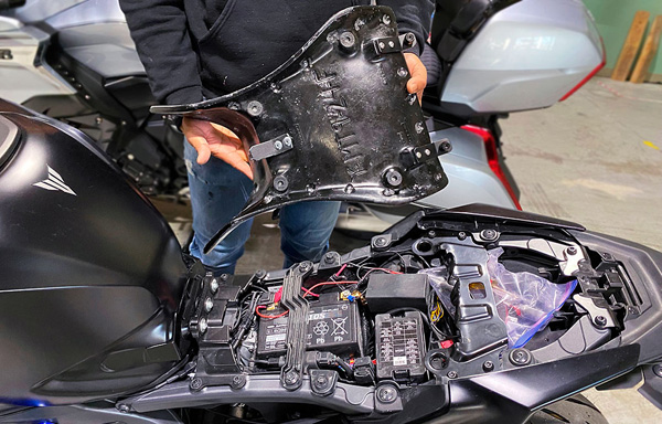 a person is holding solo seat, showing MPN printed and mounting brackets pre-installed at the rear side